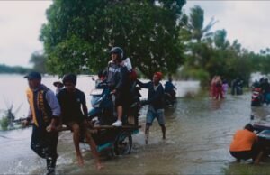 Banjir Lumpuhkan Jalan Raya Pulo Rengas, Warga Gunakan Jasa Dorong Motor